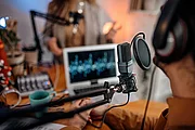 Studio-Schreibtisch mit Podcast-Mikrofon und Bildschirm