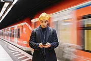Ein Mann sucht auf dem handy nach der besten Bahn-Alternative