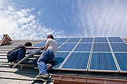 Solarpaneele werden auf einem Gebäudedach montiert
